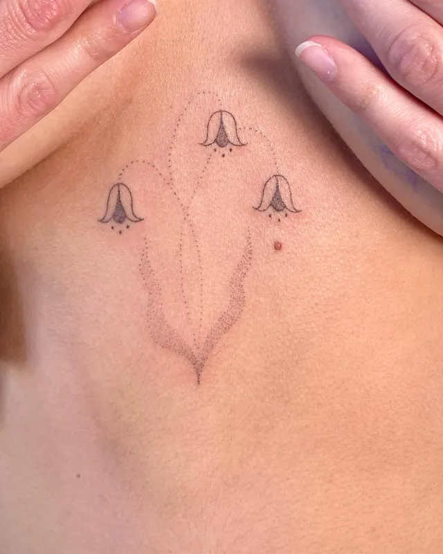 Delicate dotwork bellflower tattoo on a sternum