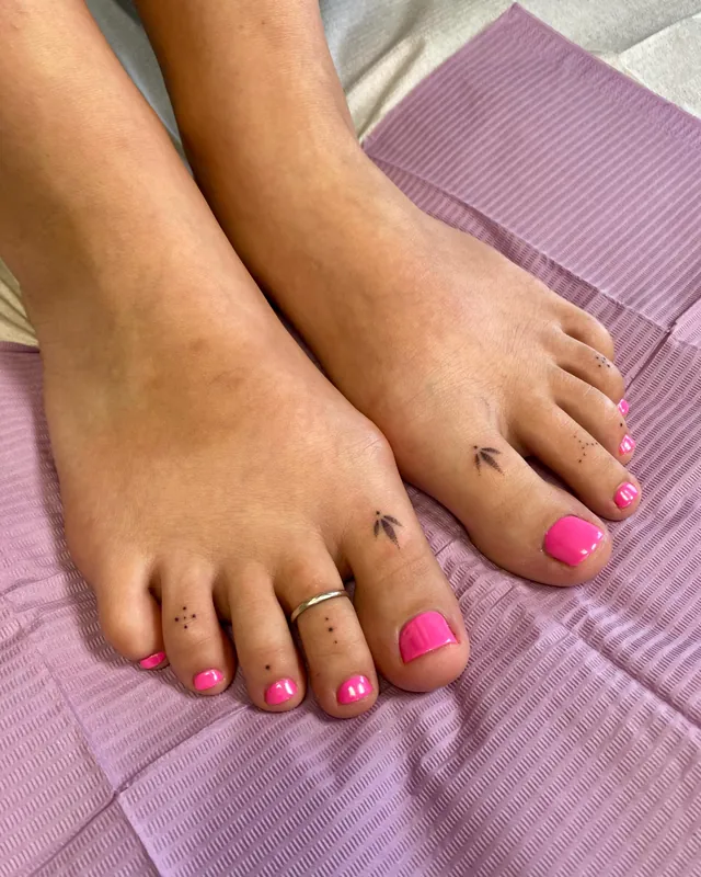 Tiny hand-poked tattoos on toes